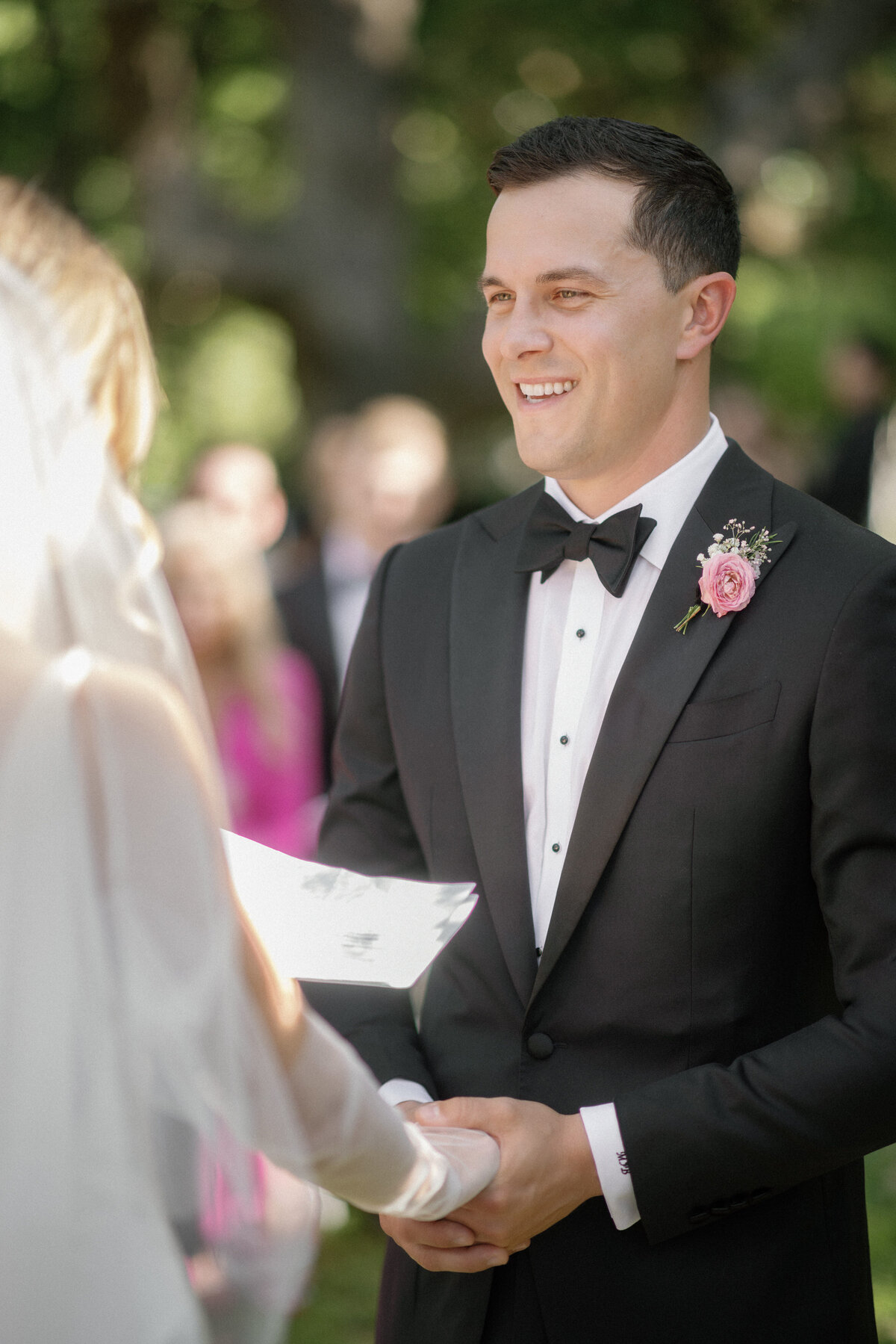 groom smiling at bride during outdoor wedding ceremony