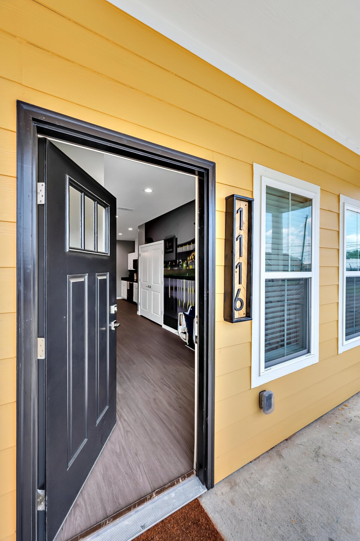 Front door entry way opening up to this four-bedroom, 4.5 bathroom new construction vacation rental house with free wifi, fire pit, gazebo, cornhole, private bathrooms for each bedroom within walking distance of Magnolia and Baylor in downtown Waco, TX.