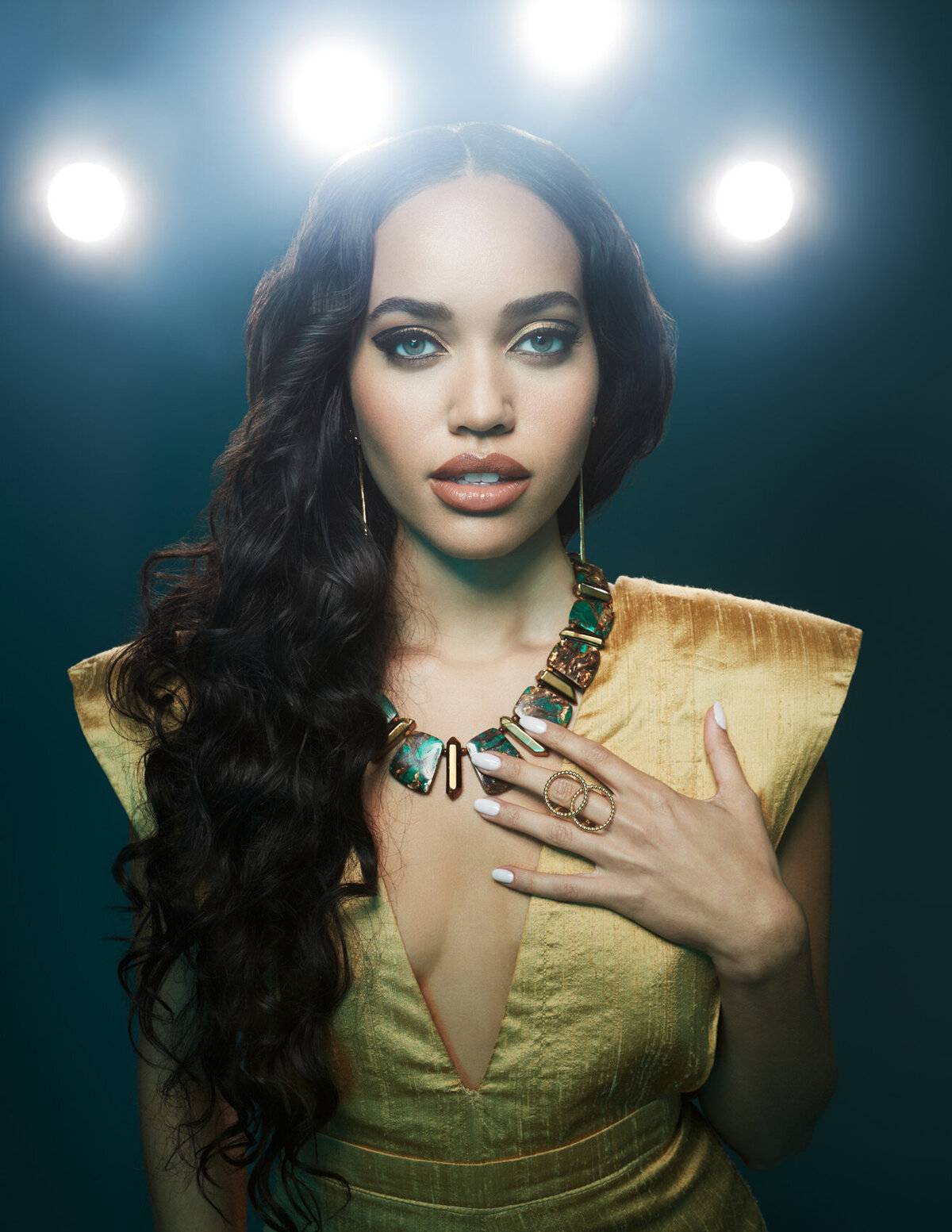 Sena in a dramatic, high-fashion portrait, featuring bold makeup and intricate styling, captured by Ylva Erevall.