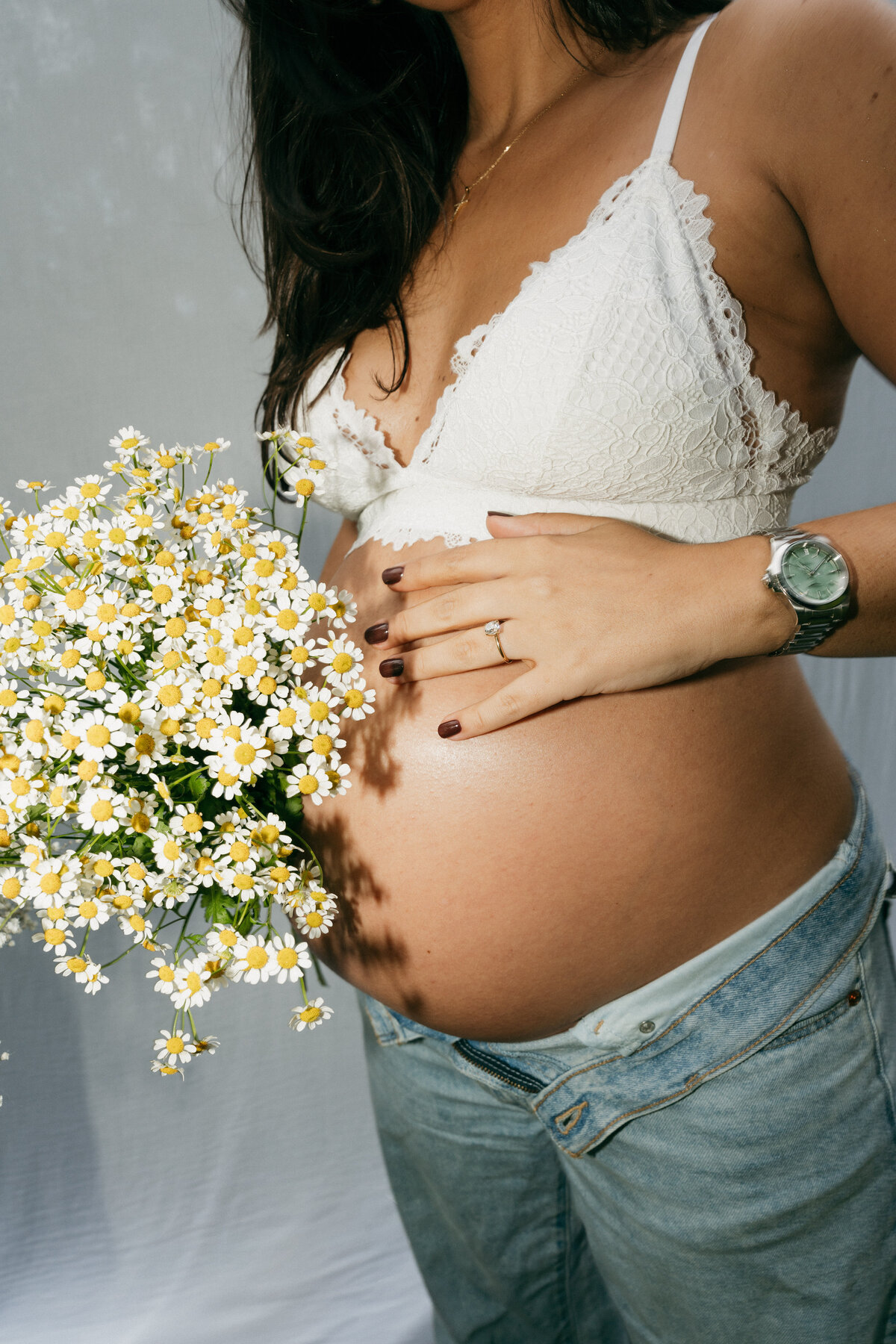 Detailfoto van zwangere buik met bloemen