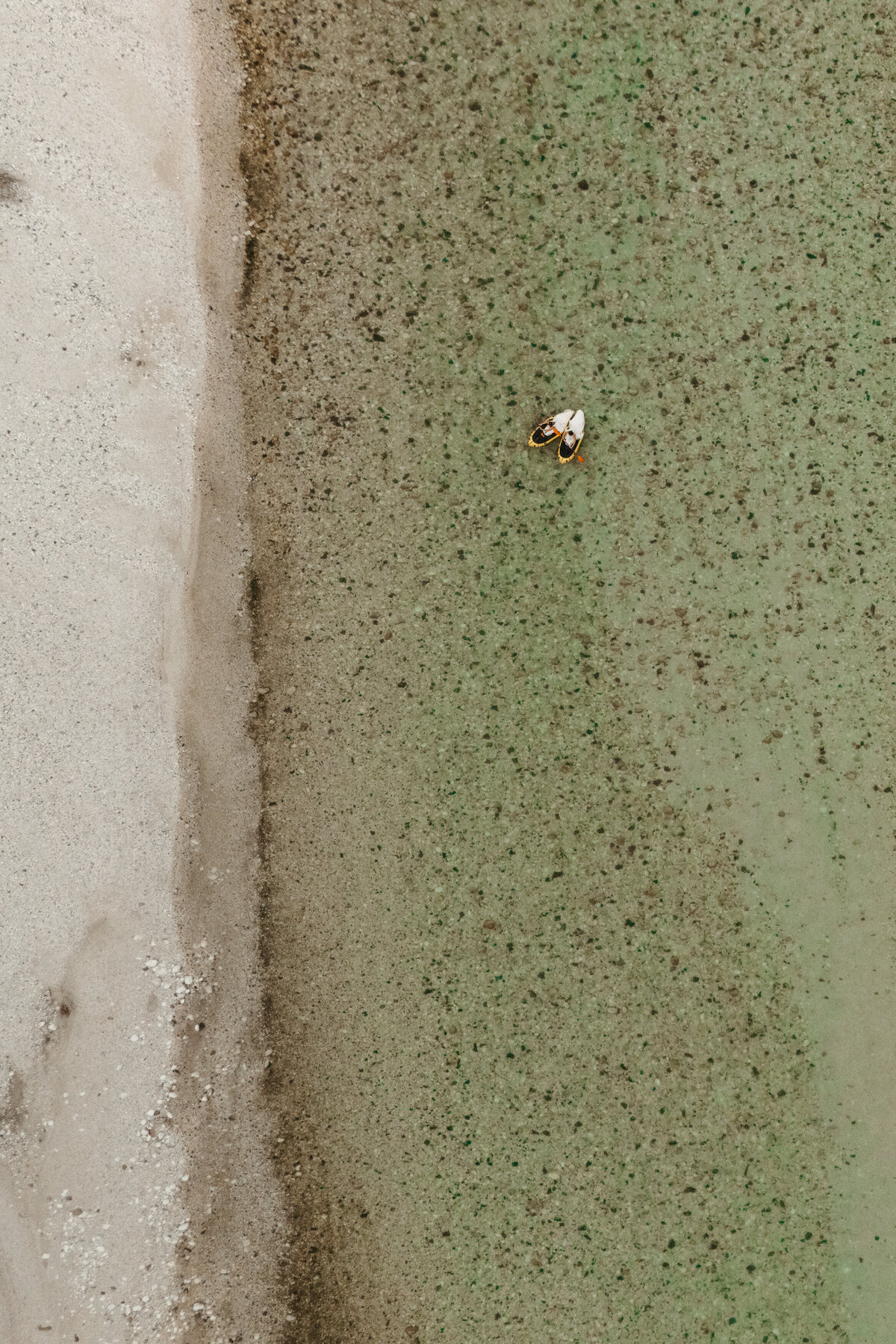 Aerial view of brides in yellow packraft in Soča Valley river elopement