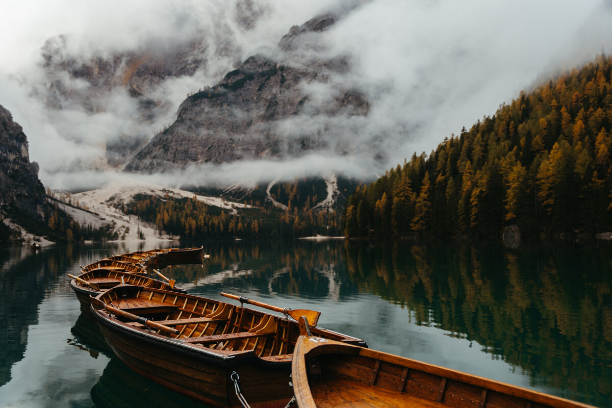 Row of wooden boats on Lago di Braies at sunrise