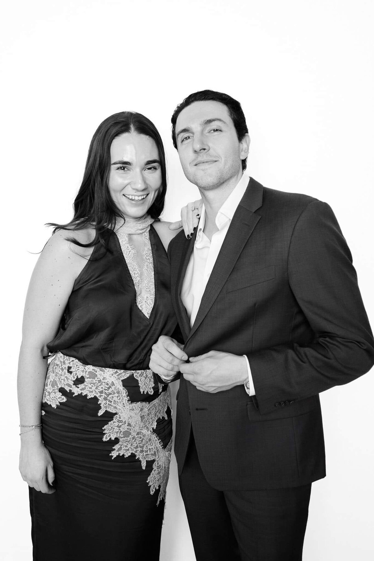 A couple dressed in formal evening wear posing confidently in a black and white portrait created by Monochrome Portraits, a Scottsdale photo booth experience.