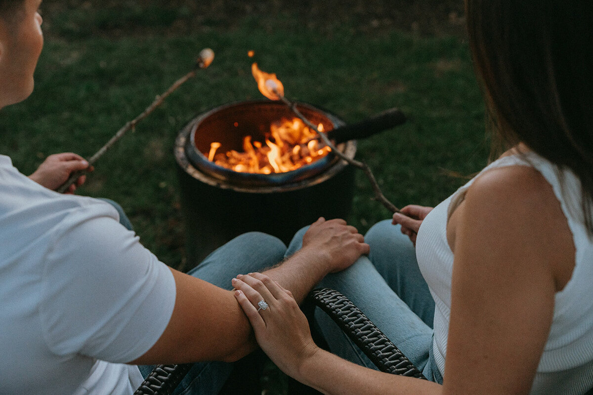 couple roasting marshmallows during engagement photos, captured by Elsie Goodman, an NYC engagement and couples photographer