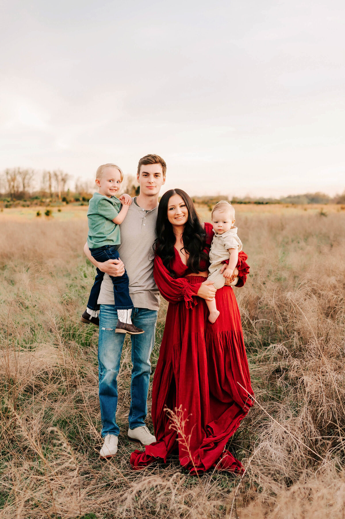 family standing ad smiling in field during Branson MO family photography session