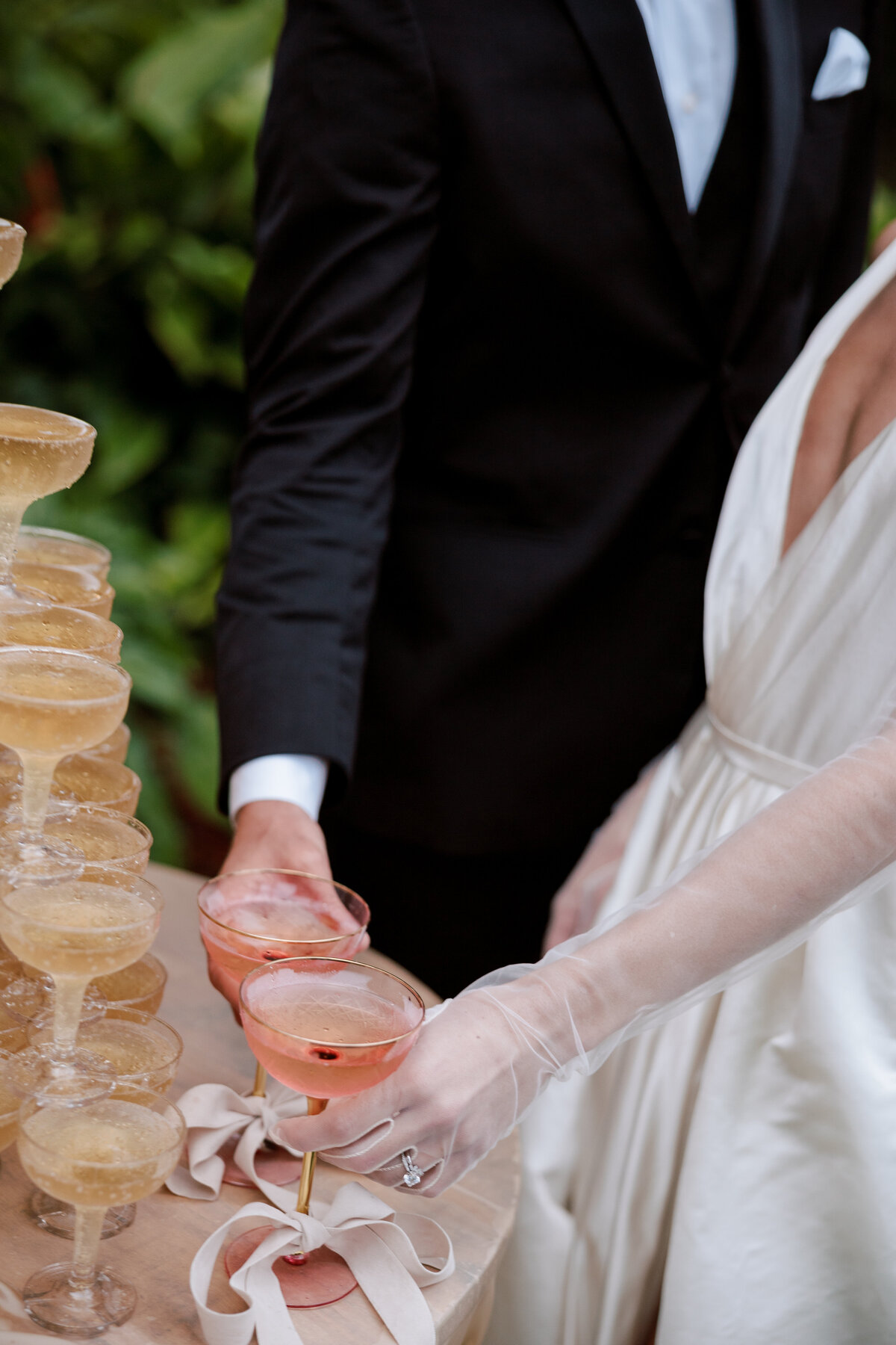 Candid, unposed moment of the bride and groom grabbing champagne together, captured in a classy and luxury setting with a documentary photography style — by Kate Winters Photography.
