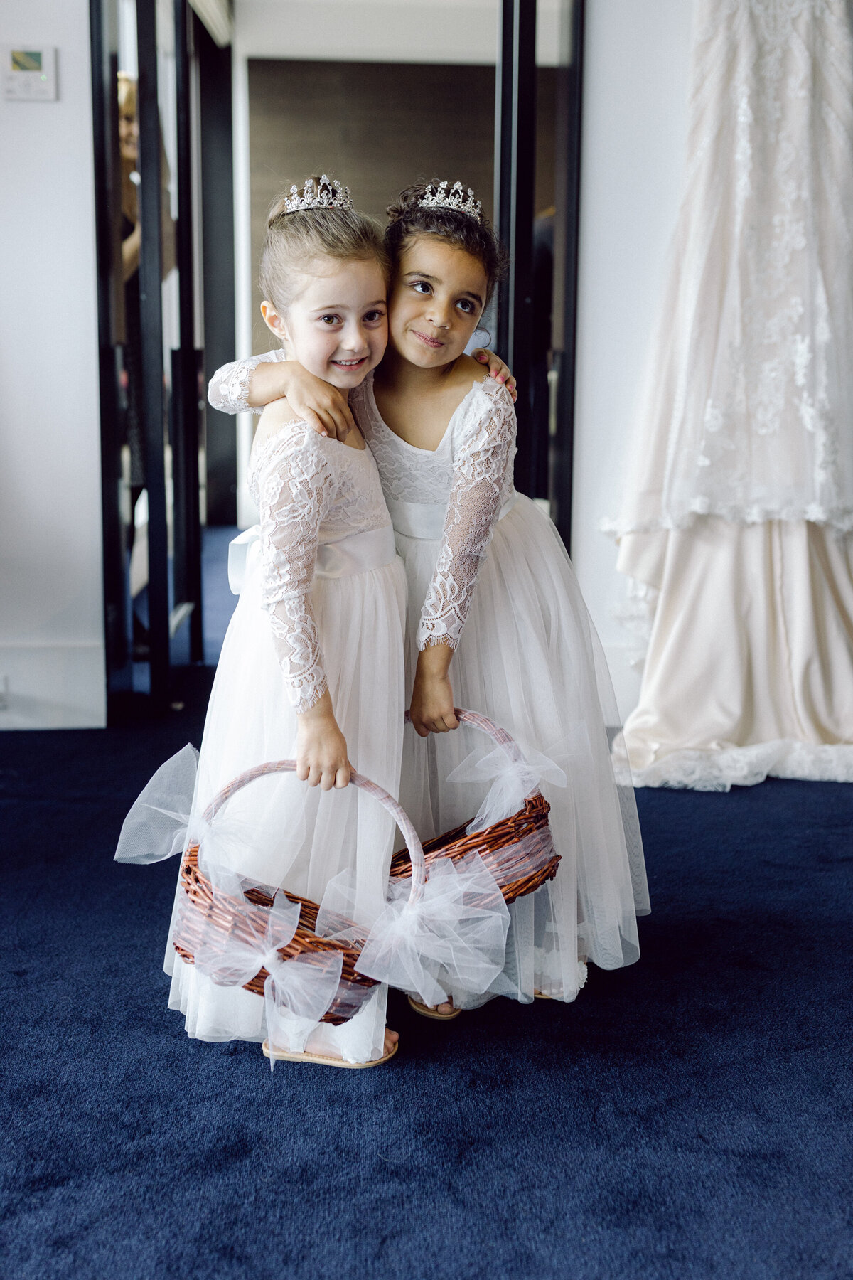 flower girls in lace dresses and princess crowns