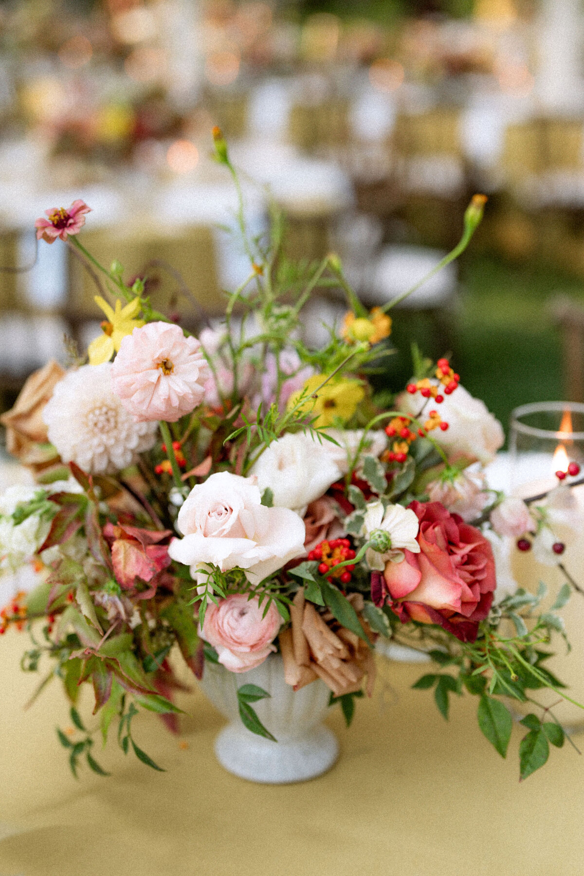 Lush fall florals for low and high centerpieces at fall wedding reception. Clear tented wedding reception in the family's back yard creating an intimate wedding reception environment. Whimsical and organic floral design in colors of copper, yellow, blush,and brown. Fall florals with sweet peas, dahlias, butterfly ranunculus, roses, mums, and bittersweet berries. Design by Rosemary & Finch Floral Design in Nashville, TN.