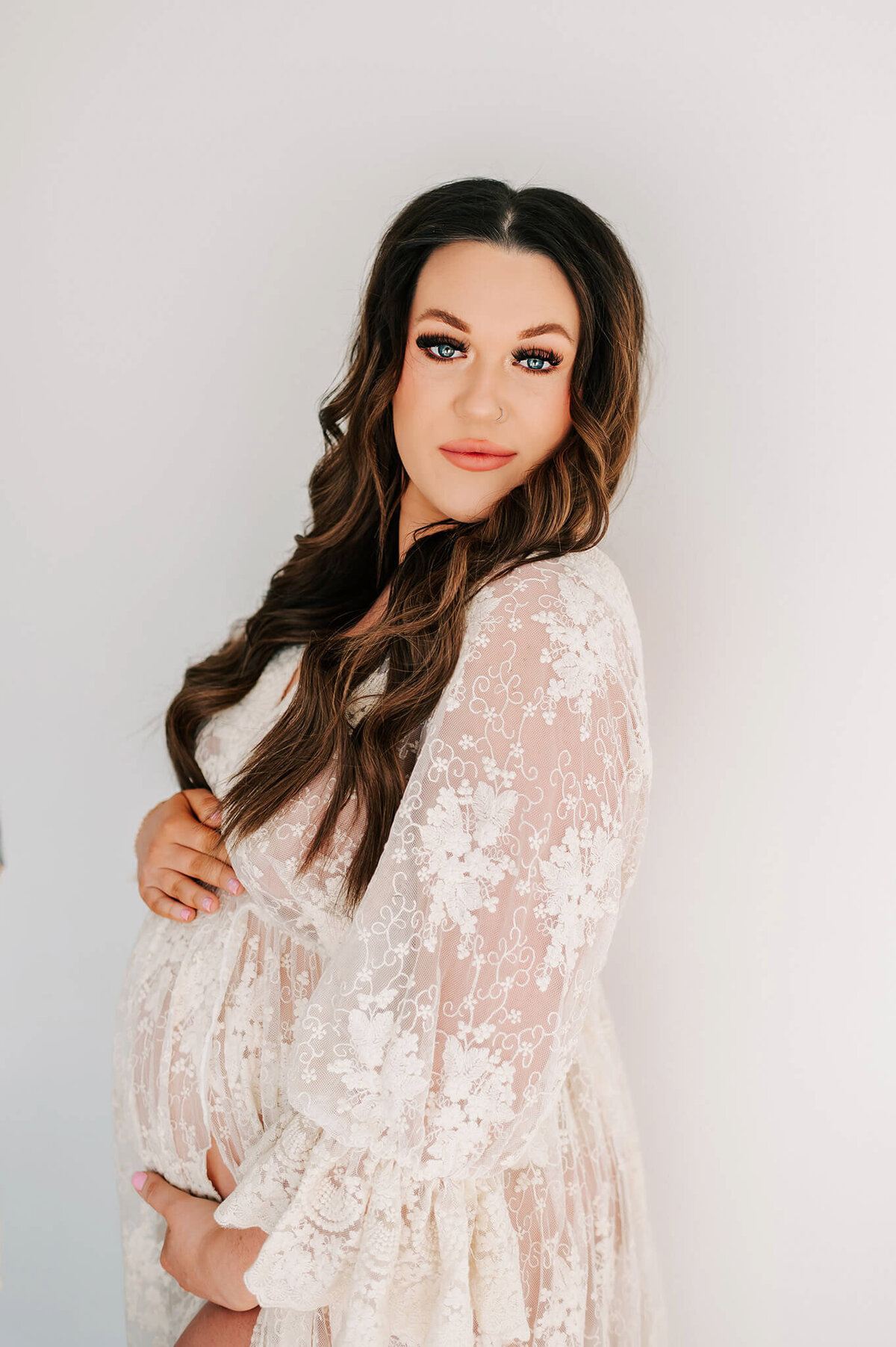 maternity photo of mom in lace dress holding baby bump during Joplin MO photography session