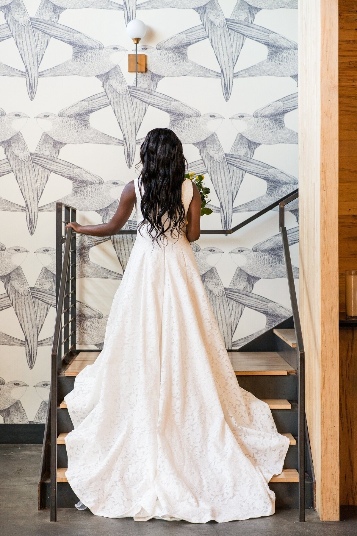 A bride walks up the staircase at her wedding at Whitaker and Atlantic in Raleigh, NC.