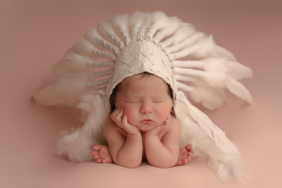 Newborn photography with baby in feather costume