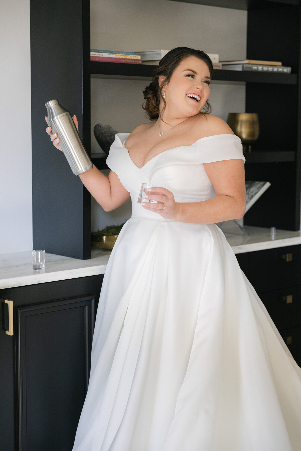 candid portrait of the bride shaking a cocktail at The Adolphus in Dallas, capturing a fun and lively moment during the wedding celebration.