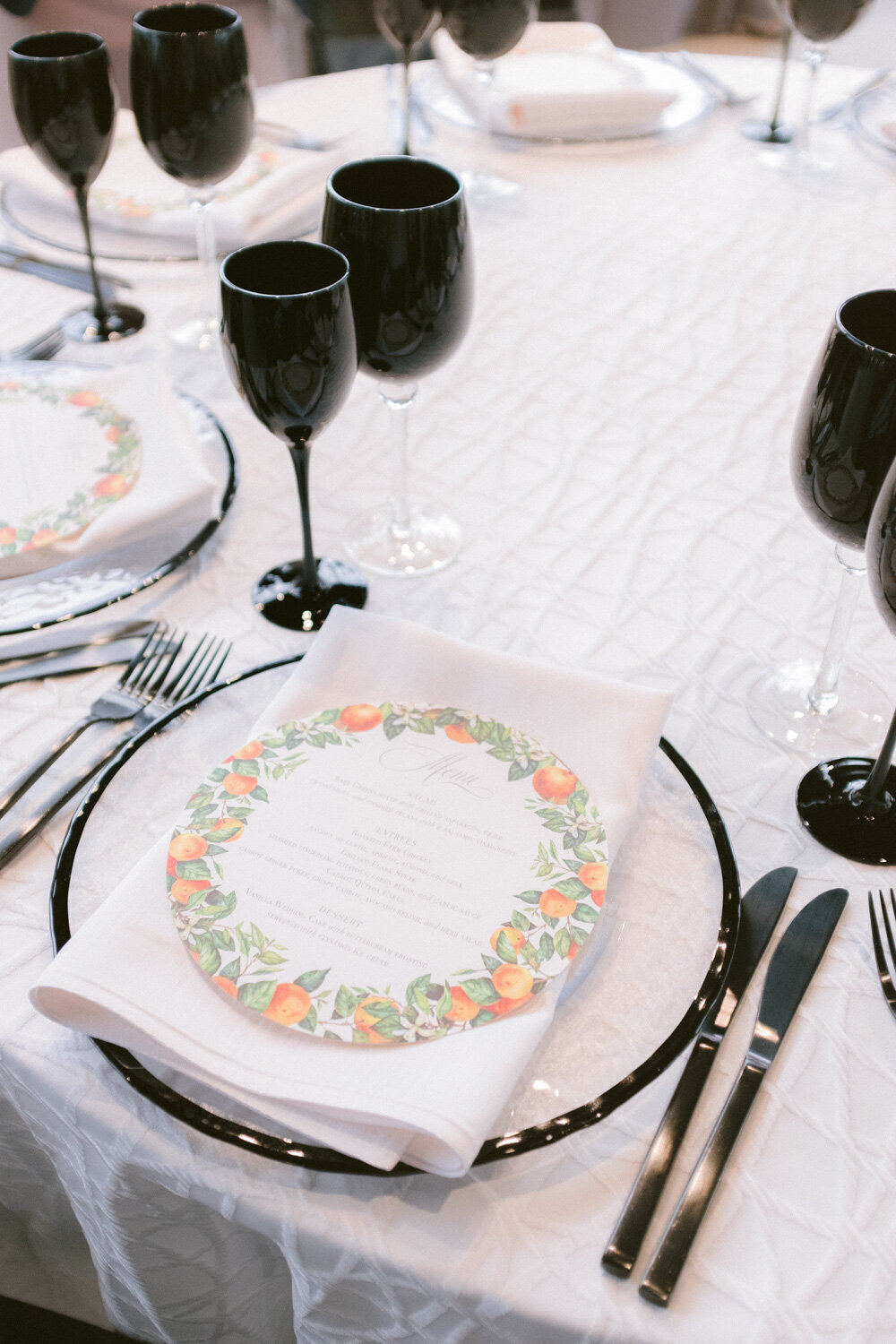 Elegant wedding table with white and black plate, black cutleries and wine glasses