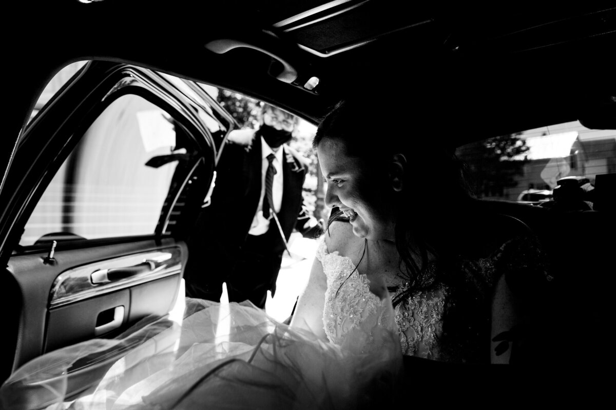 One of the top wedding photos of 2020. Taken by Adore Wedding Photography- Toledo, Ohio Wedding Photographers. This photo is of a bride in a limo getting out at her wedding ceremony in Toledo Ohio