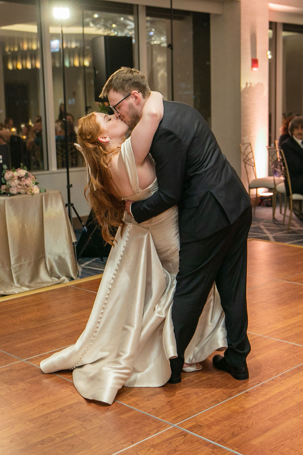 A bride and groom kissing on a dance floor