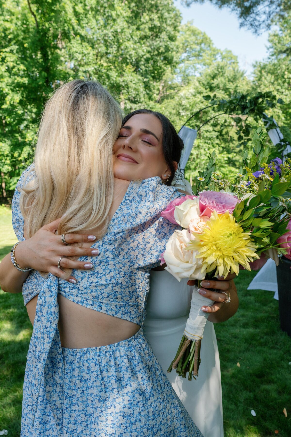 bride-and-sister-in-law-hugging-after-wedding-ceremony-backyard-wedding