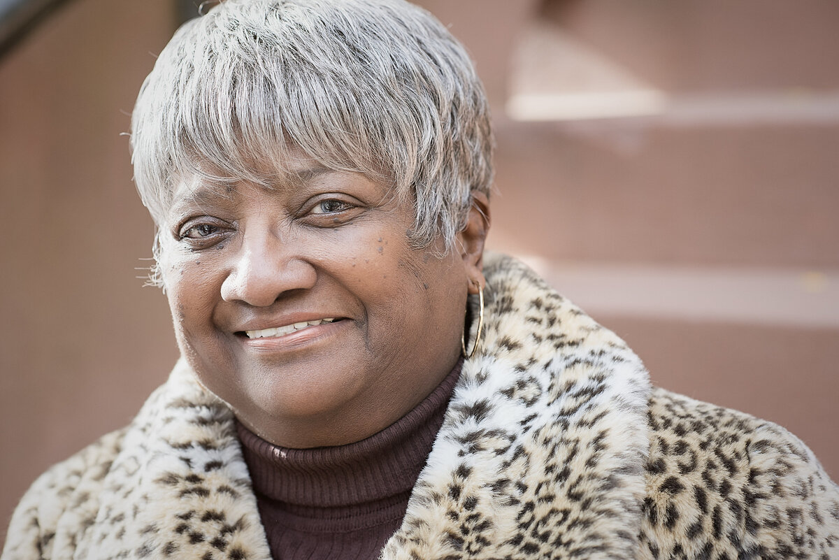 A person in a cheetah print jacket smiling