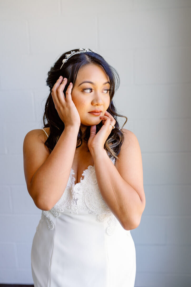 Gorgeous dark haired  filipino Bride posing after putting her dress on.