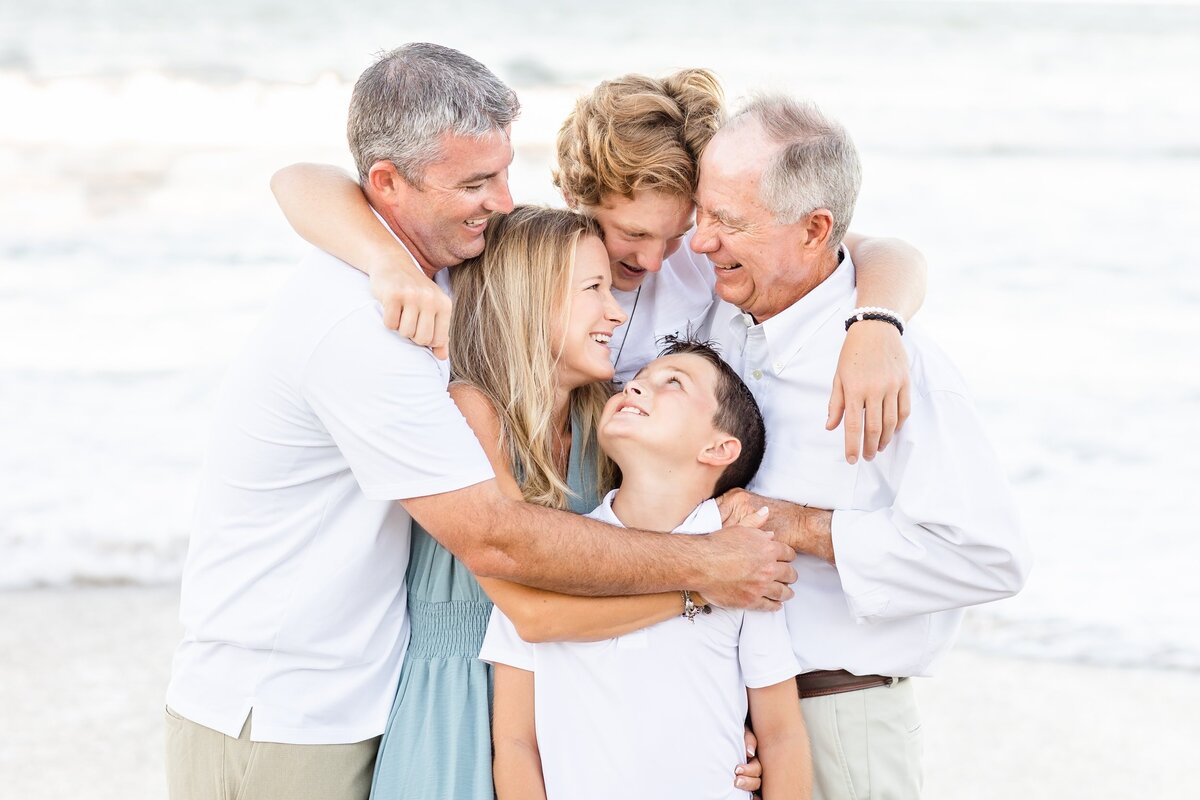 Family group hug at the beach