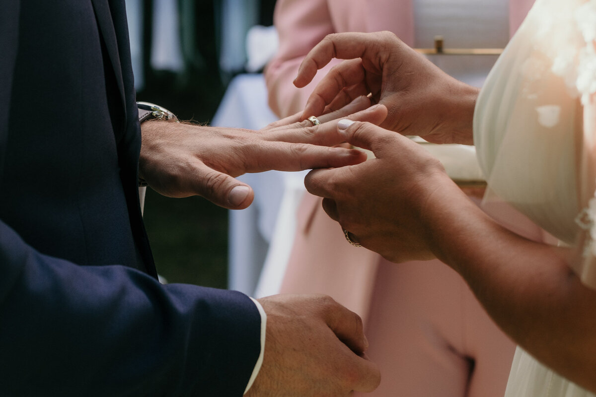 Die Braut steckt ihrem Mann den Ehering an den Finger.