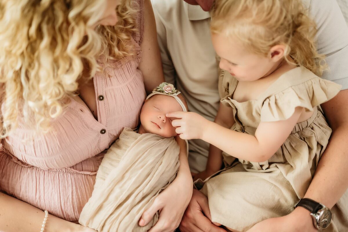 lucky baby girl surrounded by her family in the concord photo studio