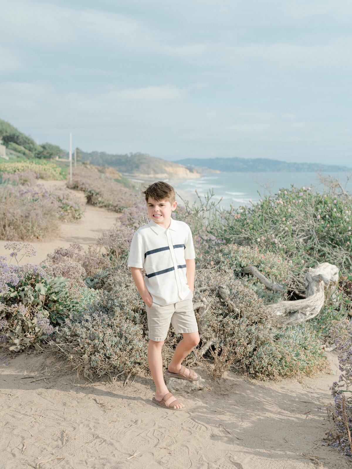 Family session with toddler standing at San Diego coast