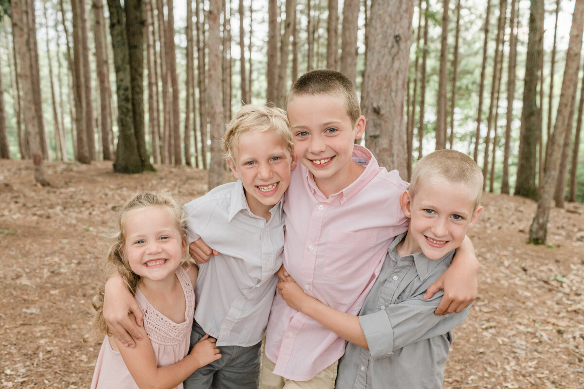 kids smiling at camera in the woods