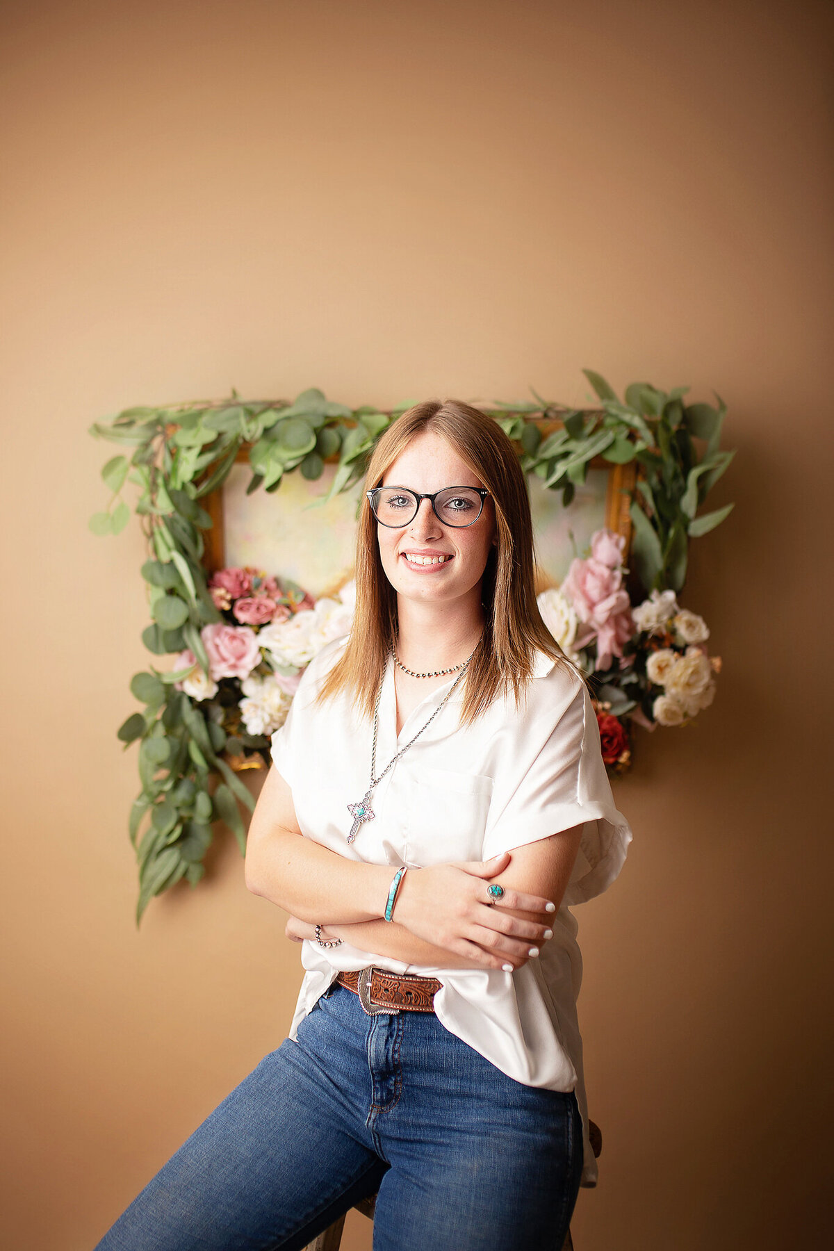 Studio senior girl with frame with flowers