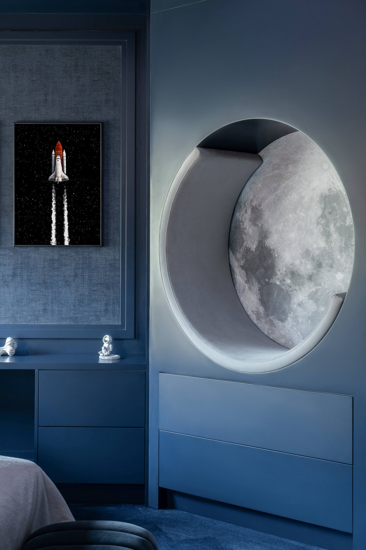 A navy blue wall with a built-in chair that looks like the moon.