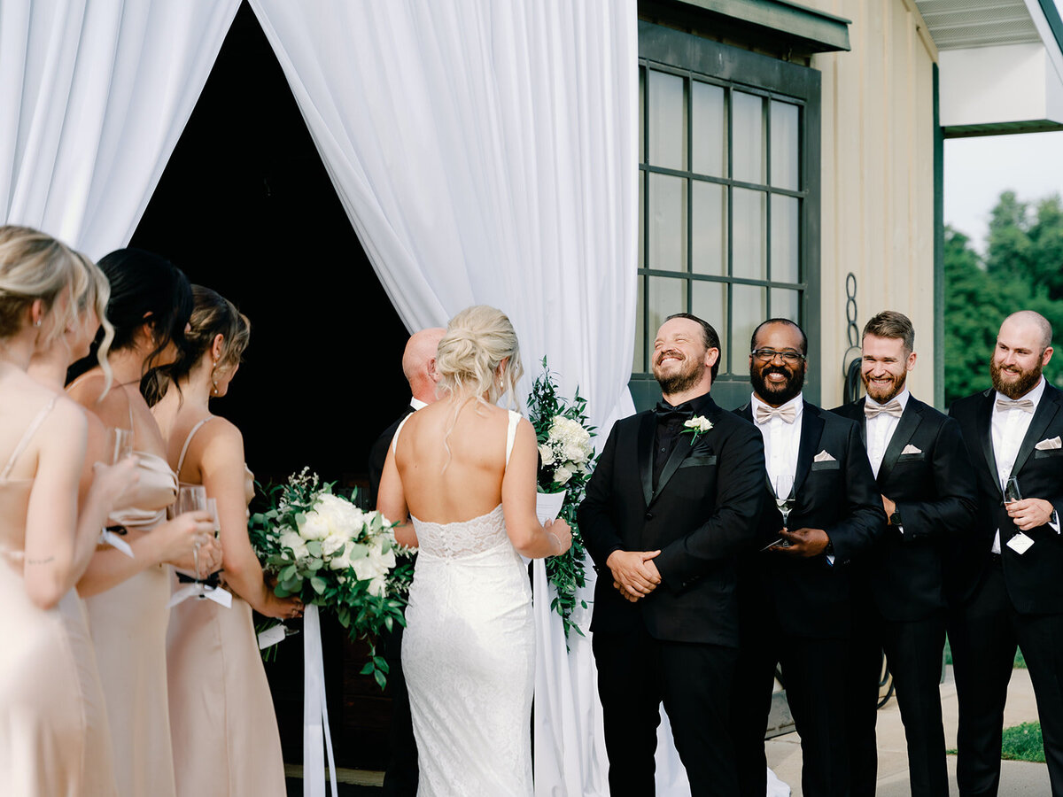 Groom laughs as they exchange vows in front of the horse stable