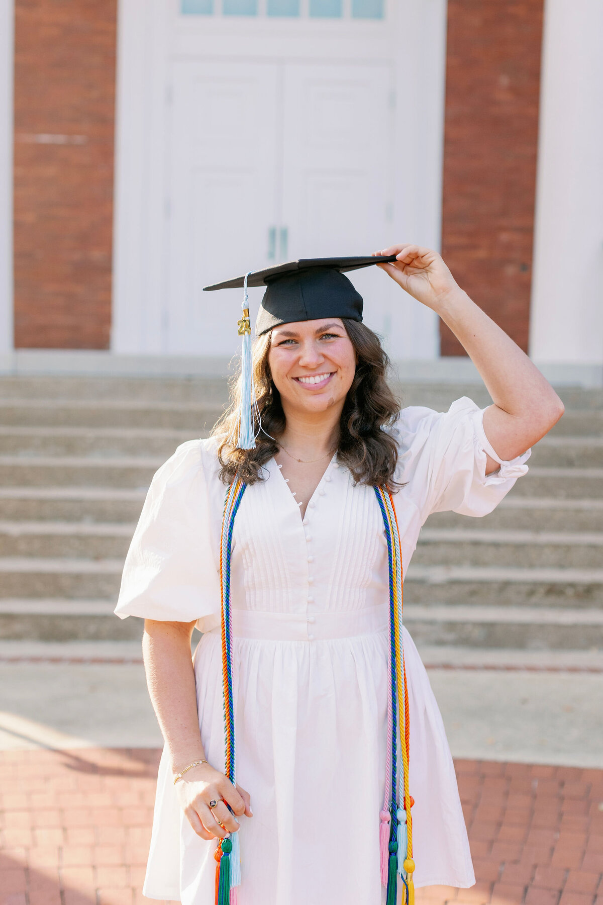 College graduate smiling with cords and cap