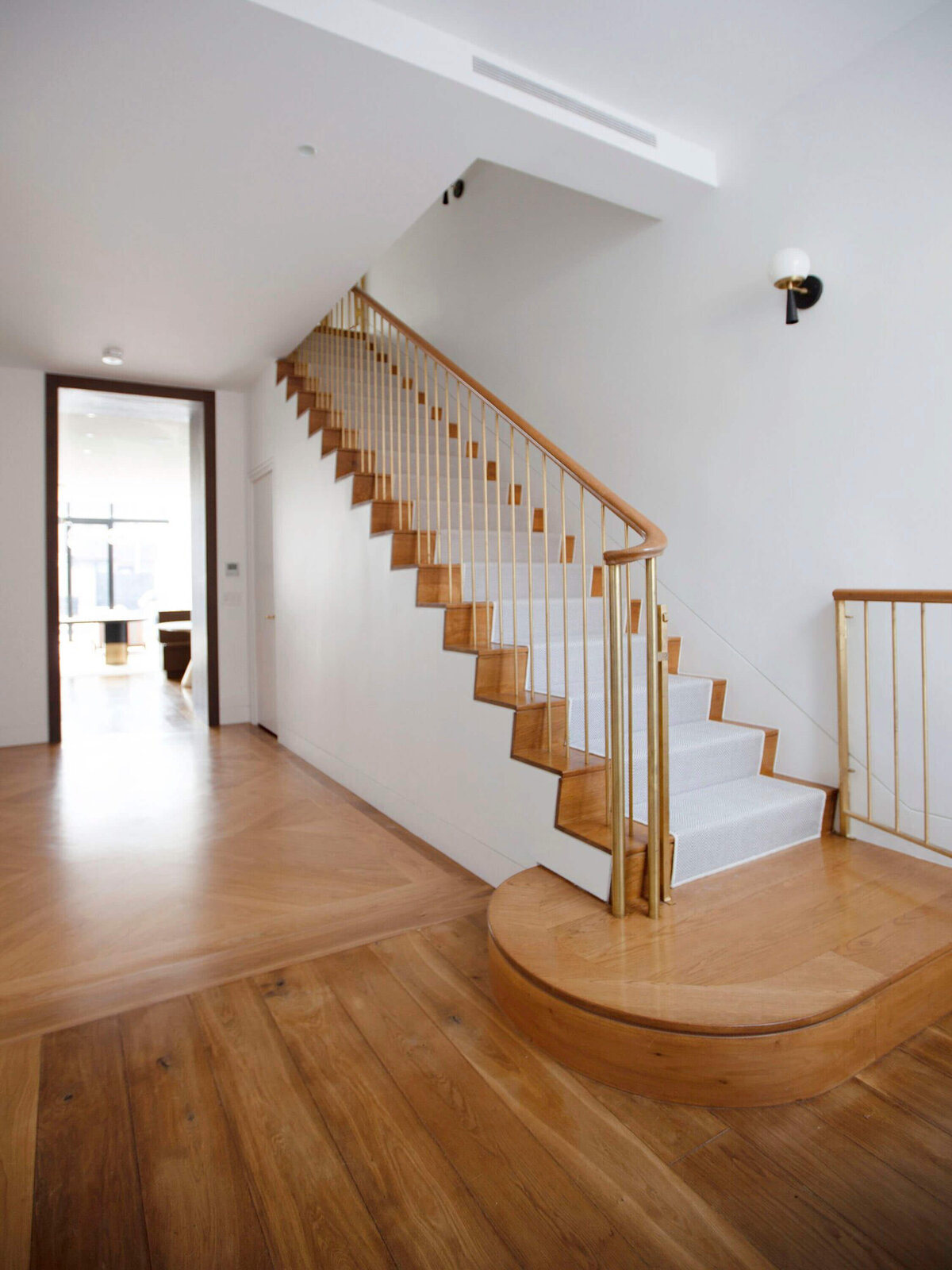 Beautiful natural wood and white stairs with gold railings.