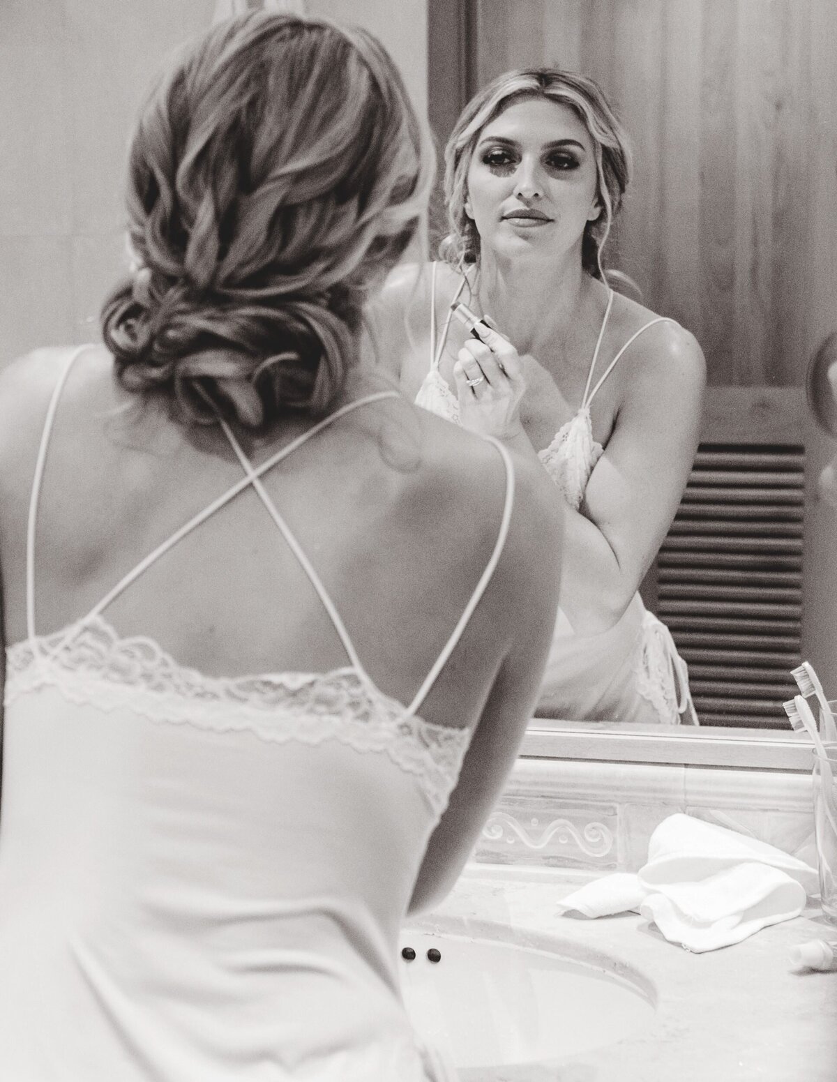 Bride looking in mirror getting ready before wedding in Riviera Maya