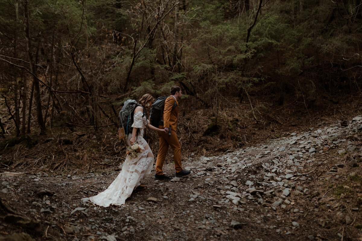 bride and groom hiking on trail