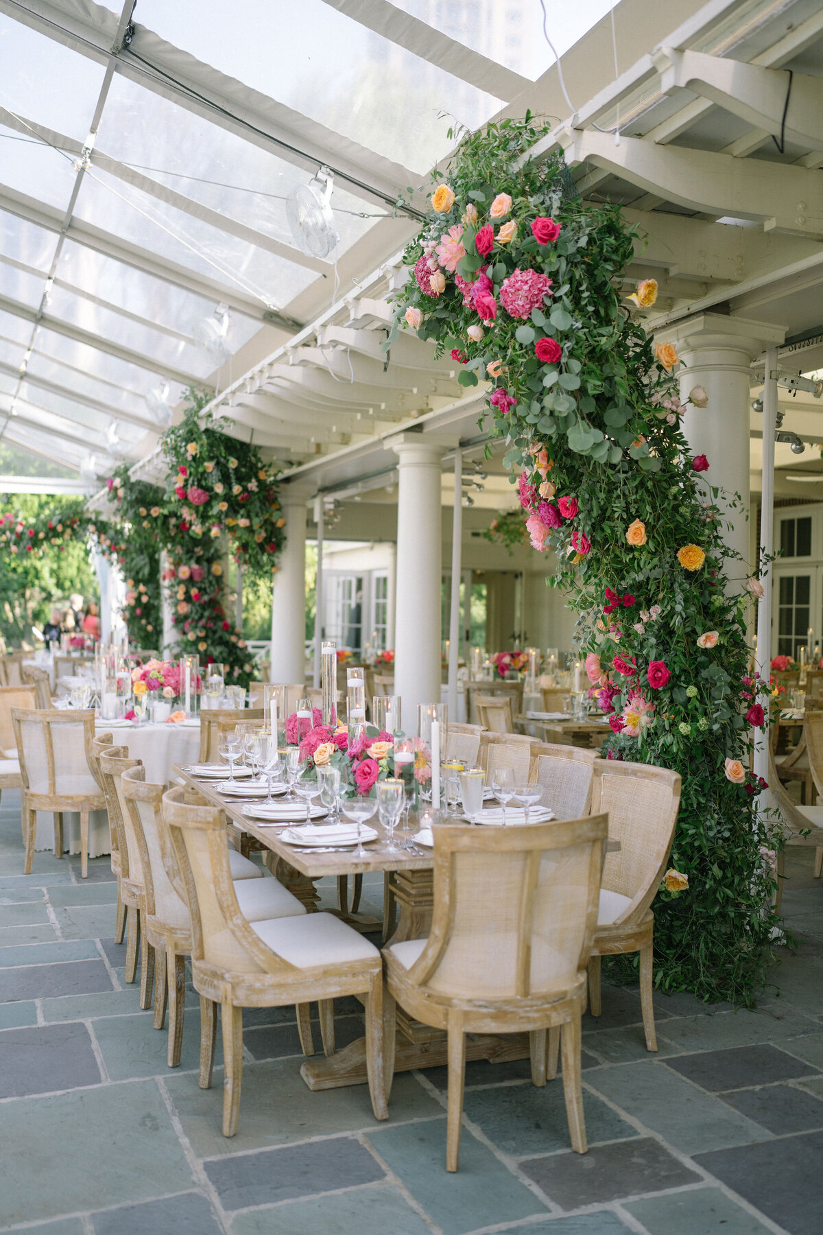 Luxurious reception dining under a floral archway at Saddle Country Club.