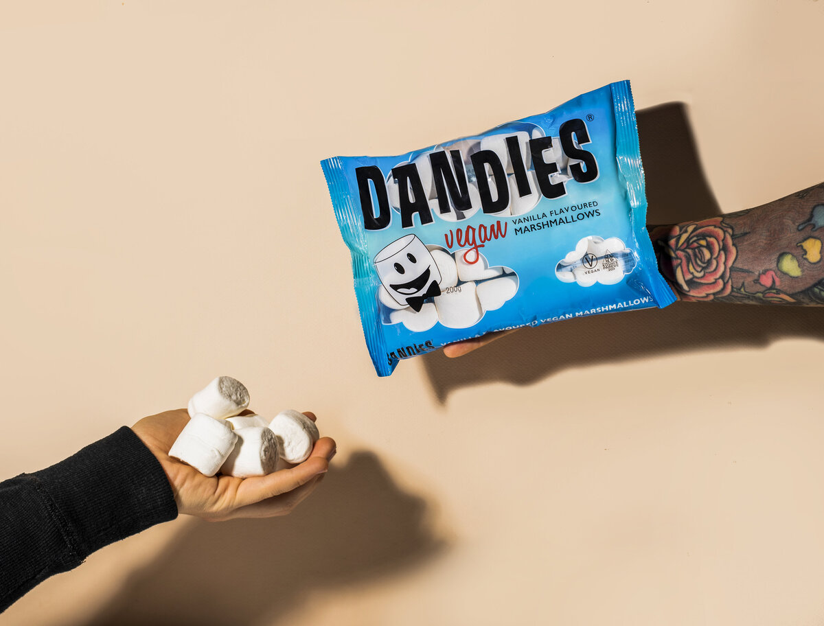 two hands sharing dandies marshmallows
