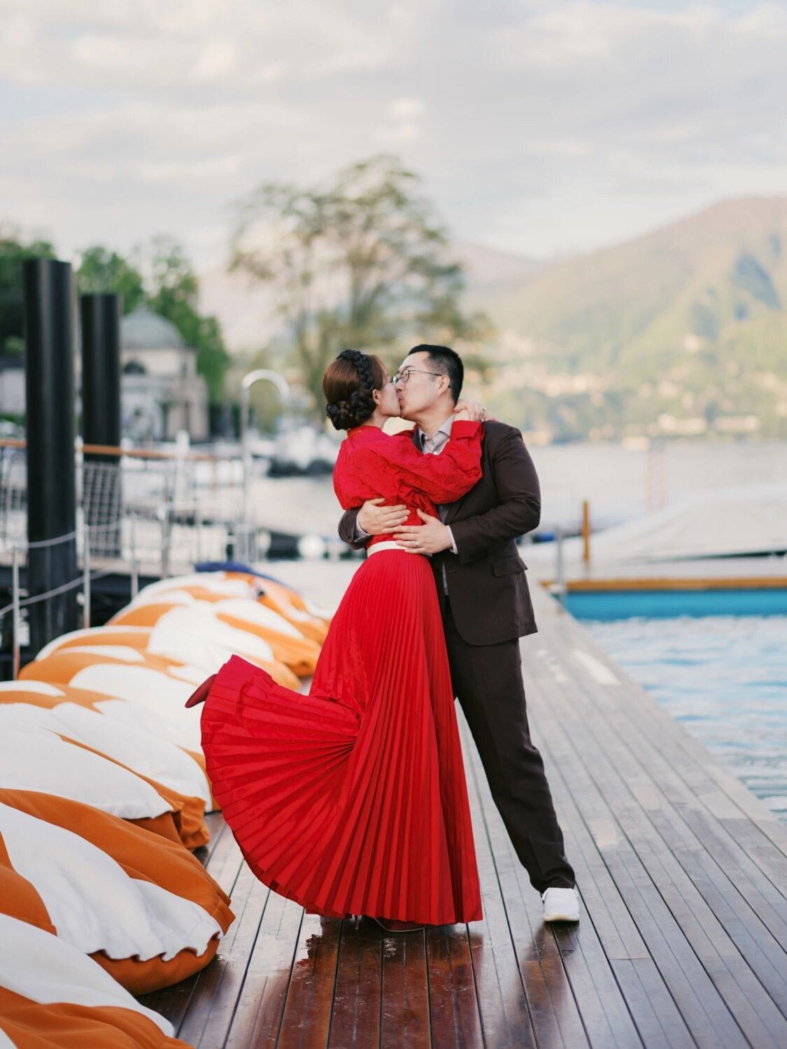 Pool-side Couple portraits during Welcome party at Grand Hotel Tremezzo wedding, bride in red Dior dress, by Lake Como wedding photographer Andreas K. Georgiou  