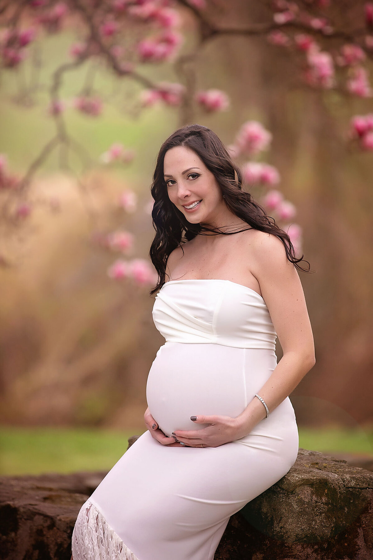 expecting mom wearing a white dress posing for her maternity portraits