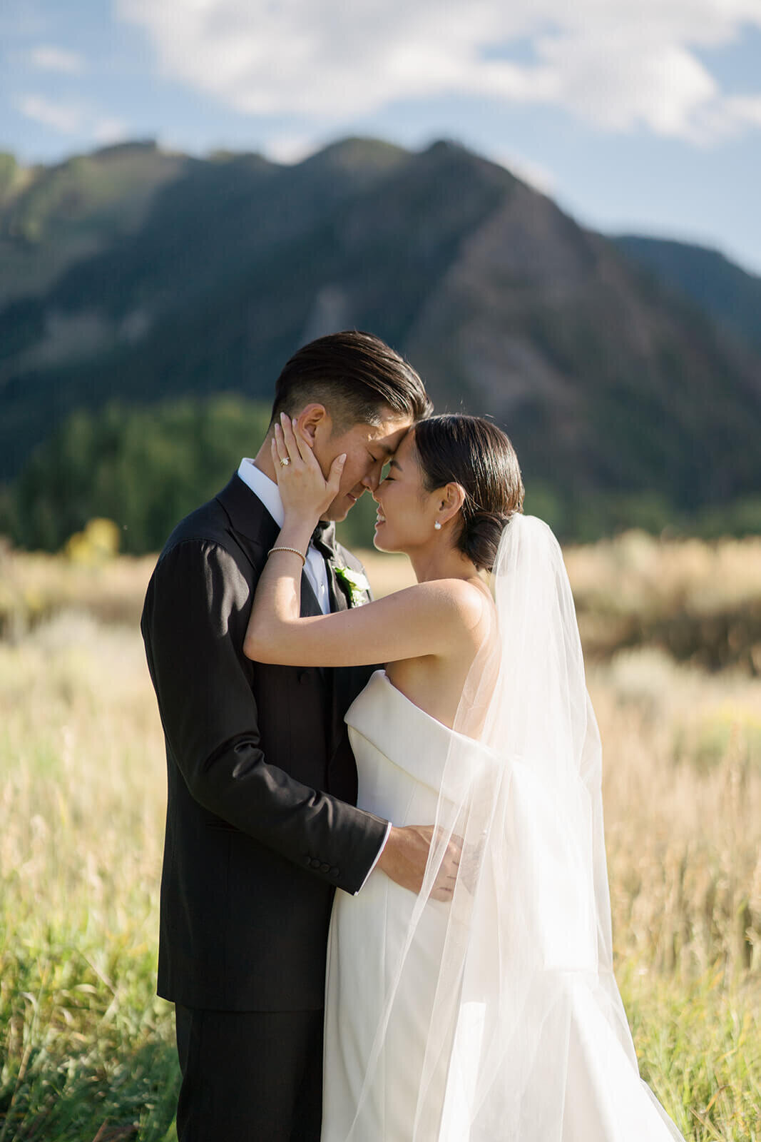Bride and groom surrounded by the mountains in Colorado after their ceremony at the Aspen Meadows Resort wedding venue.