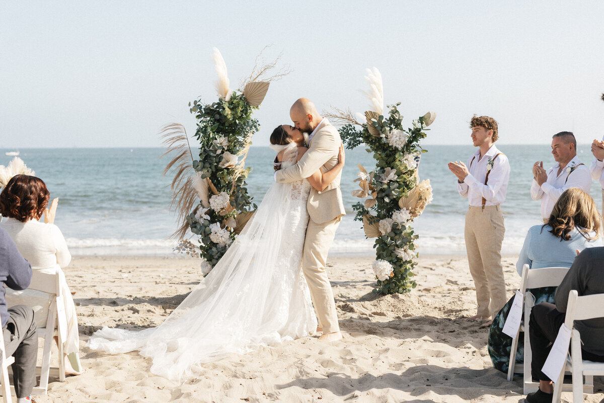 Bride and groom sharing first kiss at ceremony at Hilton Beachfront Resort Santa Barbara