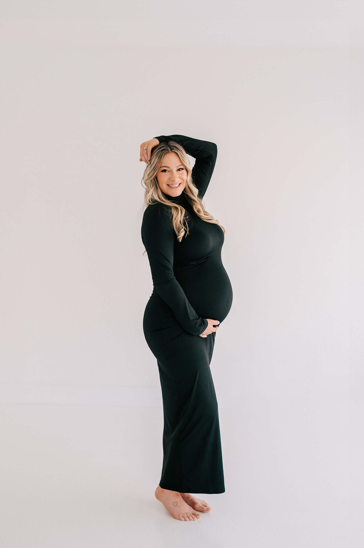 maternity photo in Joplin MO of mom in black dress smiling