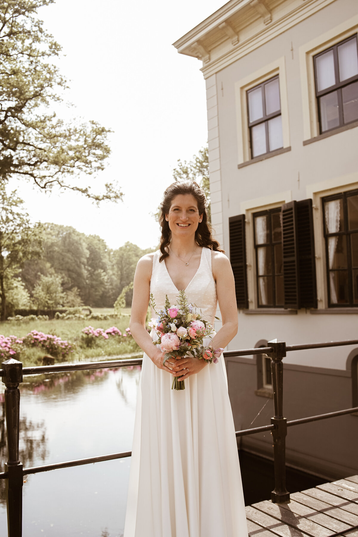 Bruidje Emma staand met boeket.