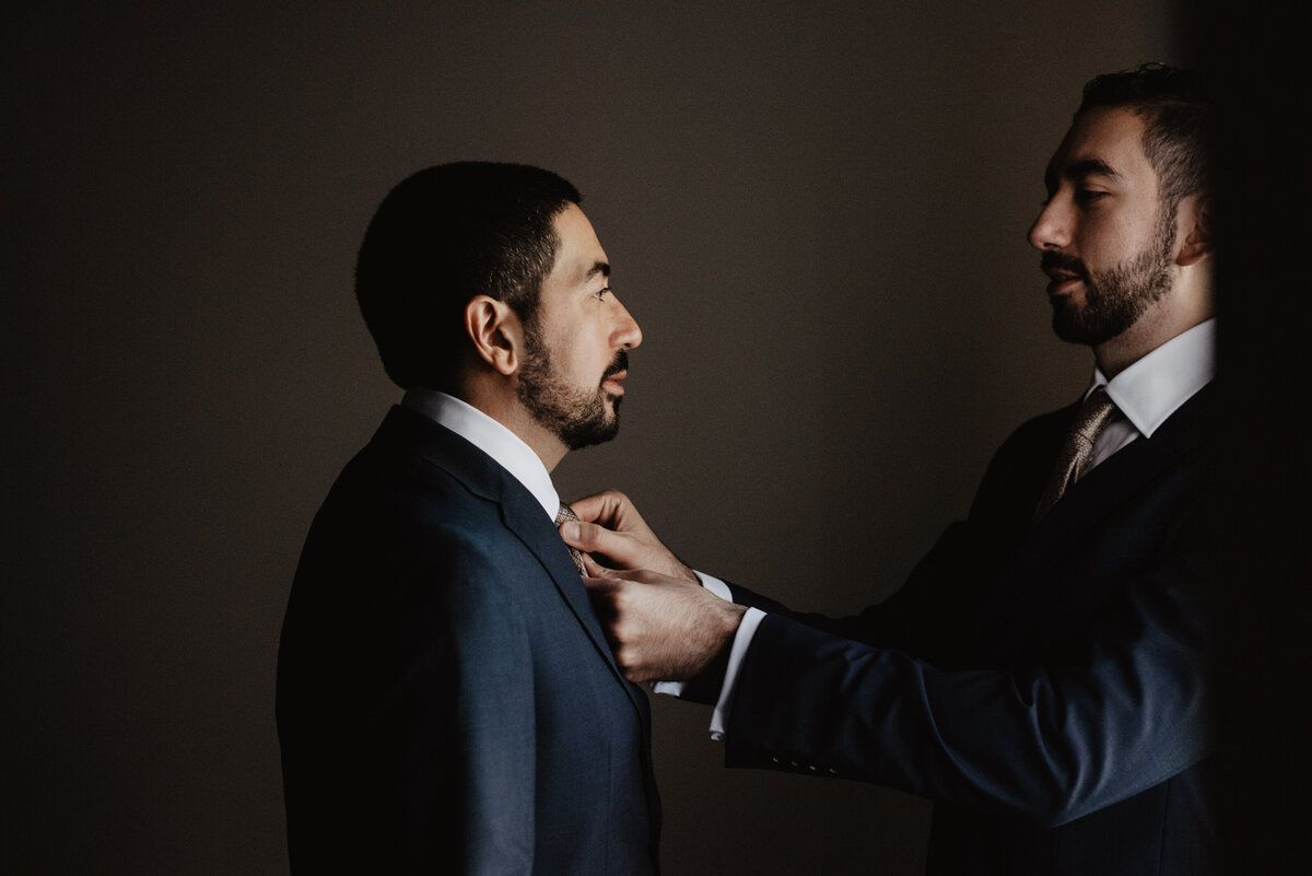 Photographers Jackson Hole capture groomsmen adjusting groom's tie