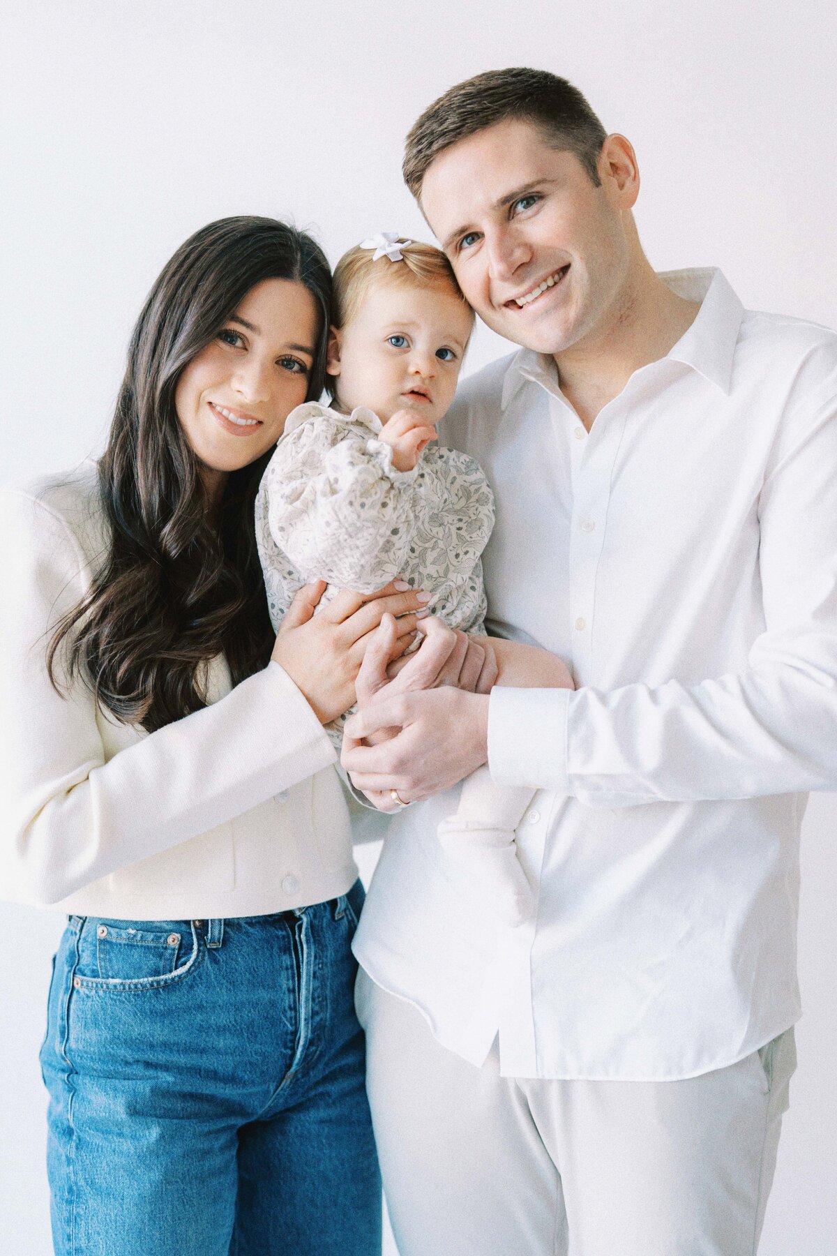 family of three smiling at camera in the studio