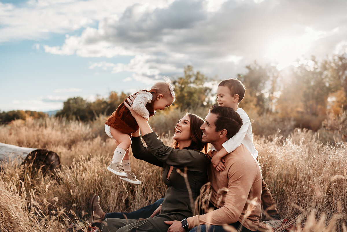 photography of family of four sitting in grass in Denver