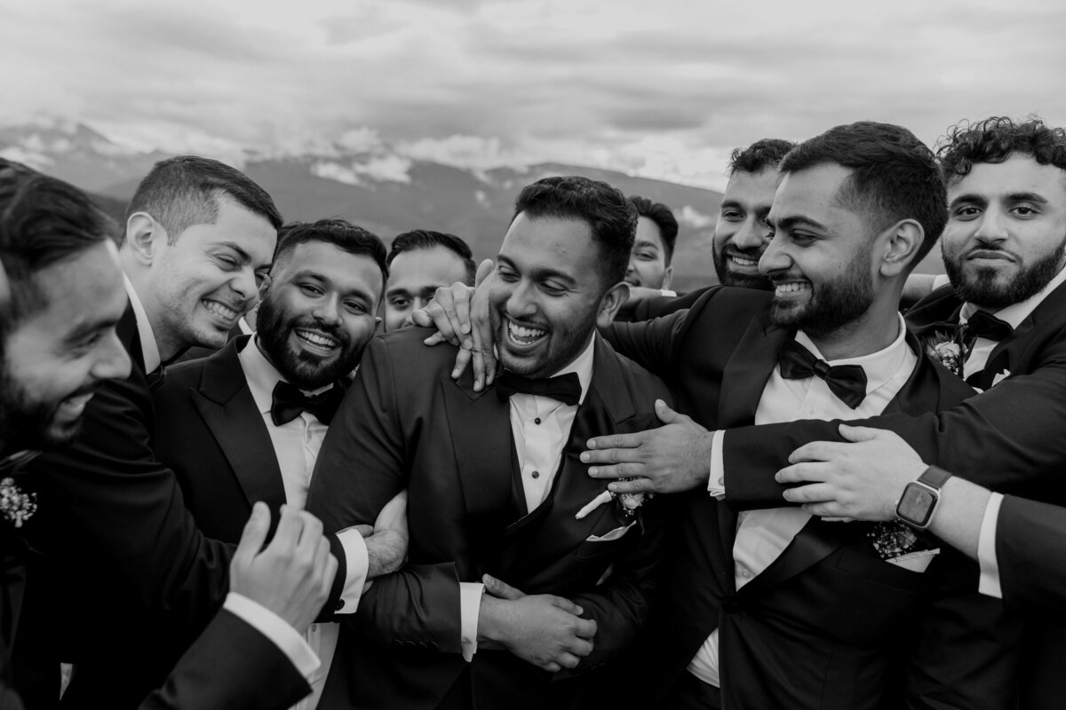 Groom and groomsmen laughing in Vail, CO