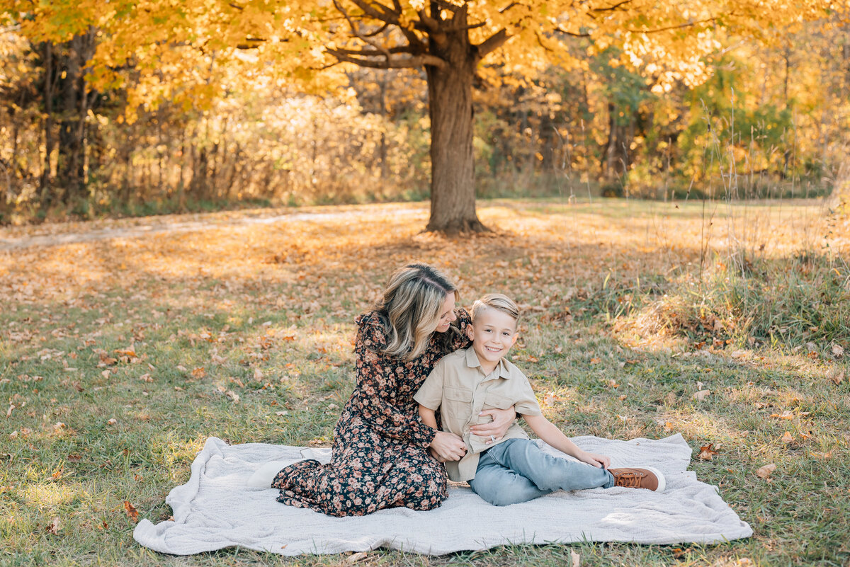 mother-son-embrace-near-golden-trees