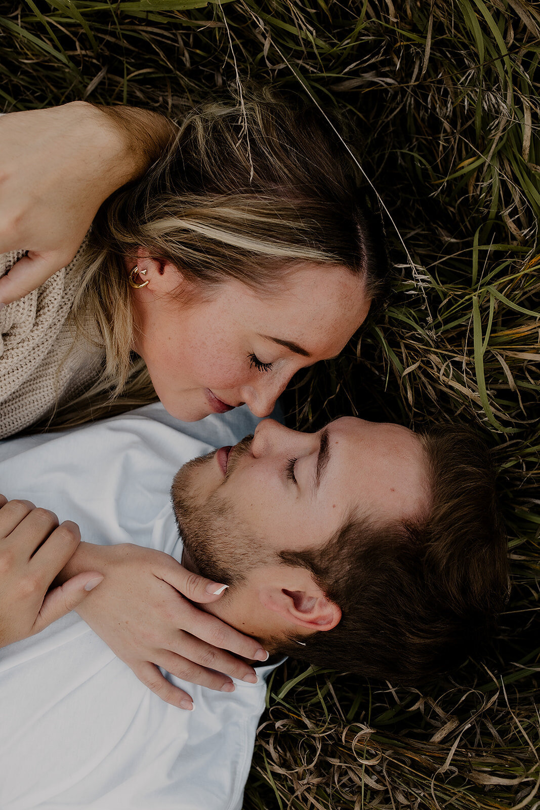 Couple's engagement session in Omaha during golden hour, surrounded by warm fall foliage – captured by Tori Nichole Photography. Authentic, romantic moments in a stunning autumnal setting, reflecting the beauty of the season and their love story.