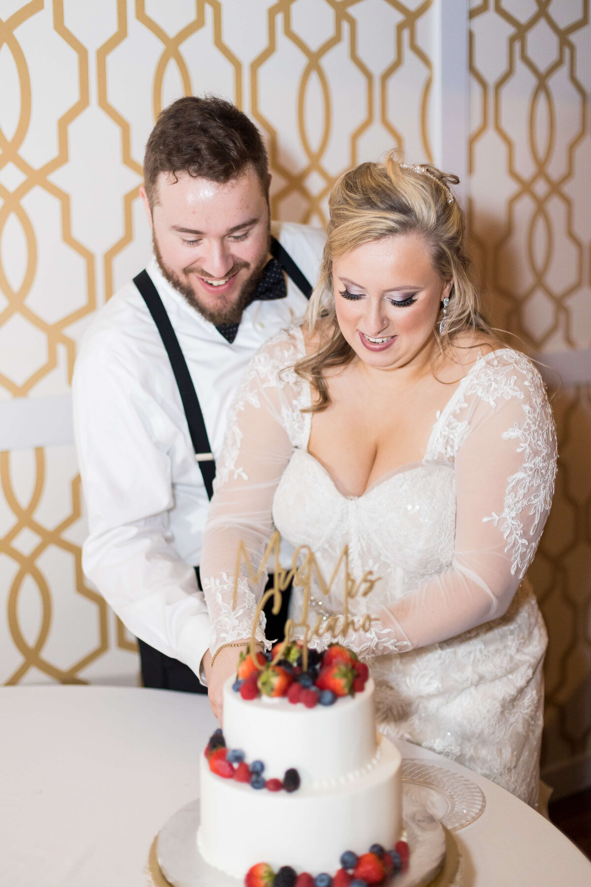 Bride and groom cutting the cake at wedding reception at  The Gatsby in Shelbyville,KY
