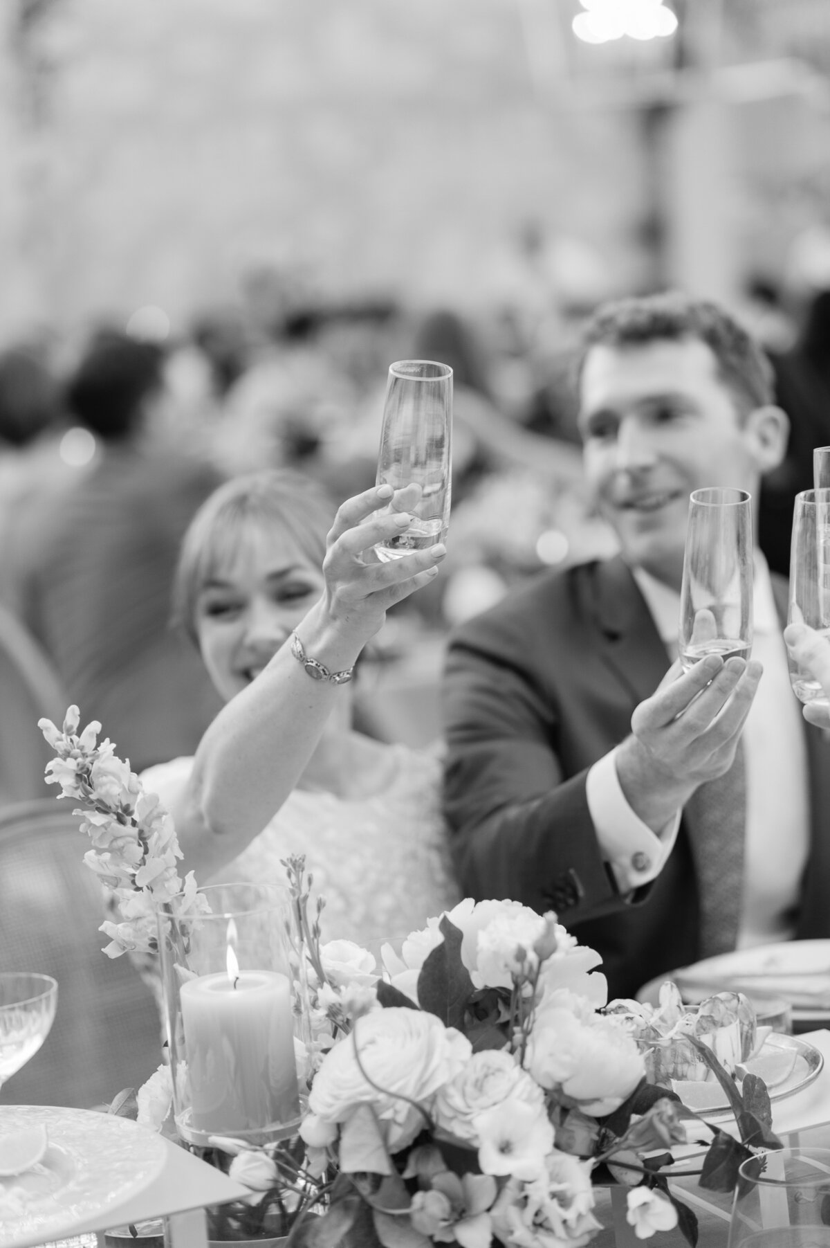 Black and white image of a bride and groom toasting at their backyard outdoor wedding planned by Spectacular Spectacular 